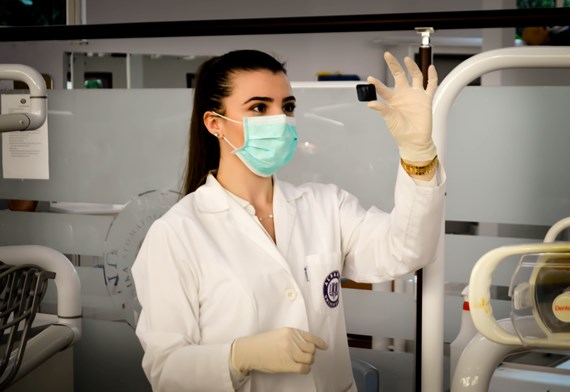 female scientist working in a lab with a face mask and gloves on